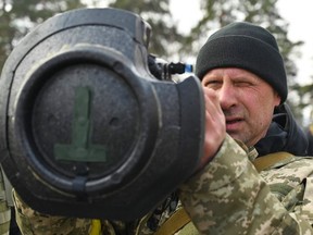 Ein Soldat der ukrainischen Territorialverteidigungskräfte untersucht am 9. März 2022 in Kiew neue Waffen, darunter NLAW-Panzerabwehrsysteme und andere tragbare Panzerabwehr-Granatwerfer.