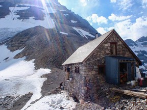 Stonemasons patch up cracks in the mortar at the Abbot Pass Hut, located at 2,926 metres along the Continental Divide.