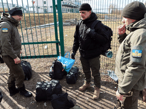 Men from Estonia prepare to cross the border from Poland to Ukraine to help fight the Russian invasion, March 10, 2022.