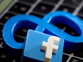 FILE PHOTO: 3D-printed images of the logos of Facebook and parent company Meta Platforms are seen on a laptop keyboard in this illustration taken on November 2, 2021. REUTERS/Dado Ruvic/Illustration/File Photo