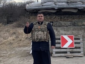 Father Yuriy, a Canadian citizen who had returned to his native Ukraine temporarily, in front of a reinforced checkpoint in Western Ukraine. The Ukrainian-Catholic priest said he and his wife are staying put and he has joined the country's Territorial Defence Force. He asked that his last name not be published for security reasons. Credit: Supplied