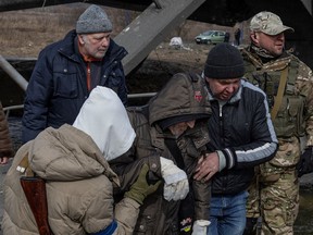 Ukrainische Soldaten evakuieren Menschen in der Stadt Irpin außerhalb von Kiew, Ukraine, während der russische Einmarsch in die Ukraine weitergeht.