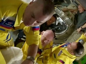 Die russischen Kosmonauten Oleg Artemyev, Denis Matveev und Sergey Korsakov kommen in gelben und blauen Fluganzügen zur Internationalen Raumstation, nachdem sie am 18. März ihre Sojus-Kapsel angedockt haben.