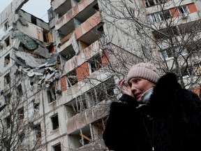 A woman reacts while speaking near a block of flats, which was destroyed during Ukraine-Russia conflict in the besieged southern port city of Mariupol, Ukraine.