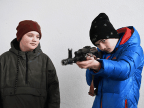 Children learn how to use an AK-47 assault rifle during a civilians' self-defence course in Lviv, Ukraine, March 4, 2022.