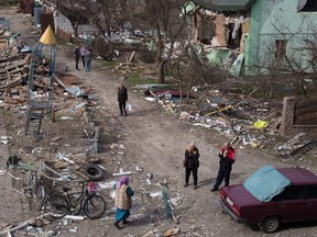 People meet in a destroyed residential area on Thursday in Borodianka, Ukraine.