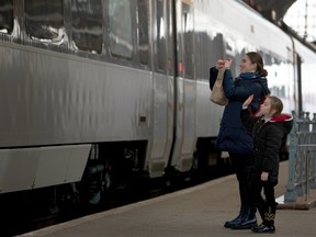 Yulia Volodina and her daughter Daria wave goodbye to friends evacuating to Poland on April 12, 2022, from the central train station in Lviv, Ukraine. Joe Raedle/Getty Images
