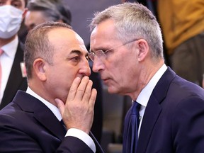 Turkish Foreign Minister Mevlut Cavusoglu (L) and NATO Secretary General Jens Stoltenberg speak at the start of the North Atlantic Council roundtable of NATO Foreign Ministers at the NATO headquarters in Brussels on April 7, 2022.