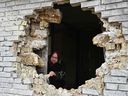 Die Anwohnerin Nadiya, 65, zeigt am 12. April 2022 ein Loch in einem Haus nach dem Beschuss im Dorf Zalissya, nordöstlich von Kiew.