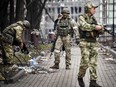 Russian soldiers walks along a street in Mariupol on April 12, 2022, as Russian troops intensify a campaign to take the strategic port city, part of an anticipated massive onslaught across eastern Ukraine, while Russia's President makes a defiant case for the war on Russia's neighbour.