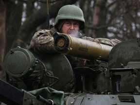 A Ukrainian soldier stands on an armoured personnel carrier (APC), not far from the front-line with Russian troops, in Izyum district, Kharkiv region on April 18, 2022, during the Russian invasion of Ukraine.