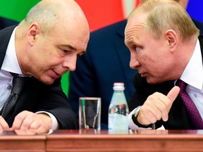 Russian President Vladimir Putin (R) and Finance Minister Anton Siluanov confer during a meeting of the Supreme Eurasian Economic Council in Saint Petersburg on December 6, 2018.