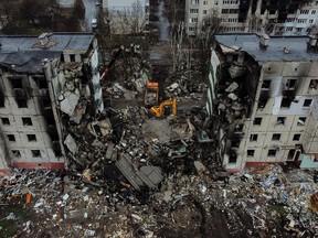 An aerial view taken on April 8, 2022, shows diggers working in the rubble of collapsed buildings in the town of Borodianka, northwest of Kyiv, Ukraine, after it was hit by Russian attackers.