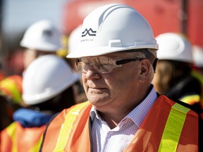 Ontario Premier Doug Ford talks to workers as he visits the starting site of the Metrolinx subway extension project in Scarborough, on April 29, 2022.