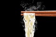 chopsticks with steaming noodles