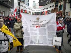Protesters carrying a copy of the Canadian Charter of Rights and Freedoms march down Yonge Street as truckers and their supporters continue to protest coronavirus disease (COVID-19) vaccine mandates, in Toronto, Ontario, Canada, February 12, 2022. REUTERS/Nick Iwanyshyn