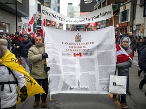 Protesters carrying a copy of the Canadian Charter of Rights and Freedoms march down Yonge Street in Toronto to protest COVID-19 restrictions, on Feb. 12.