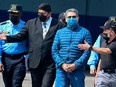 Honduras' former President Juan Orlando Hernandez is escorted by Minister of Security Ramon Sabillon, right, towards a plane of the US Drug Enforcement Agency (DEA), during his extradition to United State at the Air force Base, in Tegucigalpa, on April 21, 2022.