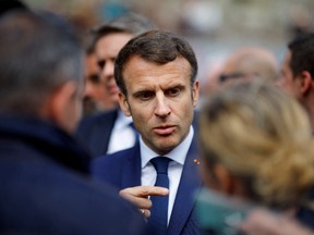 French President Emmanuel Macron, candidate for his re-election in the 2022 French presidential election, speaks with supporters during a campaign trip in Spezet, France, Avril 5, 2022.