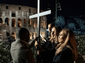 A Ukrainian and a Russian women carry a cross together during the Good Friday procession at the Colosseum in Rome, on April 15, 2022. Pope Francis has been criticized by some for the liturgic gesture meant to symbolize reconciliation and hope for peace.