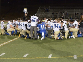 The team takes to their knees for a prayer.