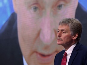 Kremlin spokesman Dmitry Peskov sits in front of a screen displaying Russian President Vladimir Putin on March 22.