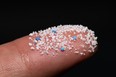 Small Plastic pellets on the finger.Micro plastic.