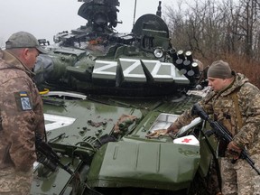 Ukrainian service members inspect a damaged Russian tank, in the Donetsk region of Ukraine, on April 13.