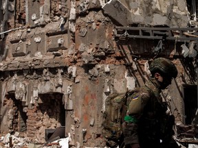 A Ukrainian soldier walks next to a destroyed building following Russian shelling, as Russia's attack on Ukraine continues, in Kharkiv on April 16.
