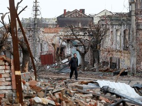 A man walks near damaged buildings in the course of Ukraine-Russia conflict in the southern port city of Mariupol, Ukraine.