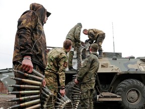 Service members of pro-Russian troops load ammunition into an armoured personnel carrier during fighting in Ukraine-Russia conflict in Mariupol on April 12.