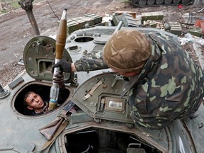 Soldaten der prorussischen Truppen laden während der Kämpfe im Ukraine-Russland-Konflikt in der Nähe eines Werks der Azovstal Iron and Steel Works Company in der südlichen Hafenstadt Granaten mit Raketenantrieb in ein Infanterie-Kampffahrzeug.