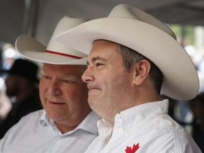 Premiers Jason Kenney, right, of Alberta, and Doug Ford, of Ontario, attend the Premier's Stampede Breakfast in Calgary, in 2019.