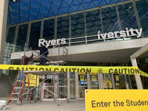 Workers replace a Ryerson University sign on April 26.
