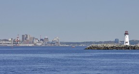 Halifax Harbour entrance with McNabs Island and lighthouse at right and Halifax in the background.