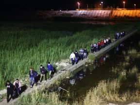 Immigrants walk from Mexico into the United States on their way to await processing by the U.S. Border Patrol on May 23, 2022 in Yuma, Arizona. Title 42, the controversial pandemic-era border policy enacted by former President Trump, which cites COVID-19 as the reason to rapidly expel asylum seekers at the U.S. border, was set to officially expire on May 23rd. A federal judge in Louisiana delivered a ruling May 20th blocking the Biden administration from lifting Title 42. (Photo by Mario Tama/Getty Images)