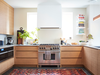 The warm oak cabinetry is by Olympic Kitchens; the linear walnut light comes from Matthew McCormick Studio.