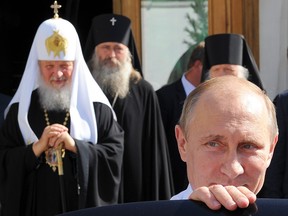 President Vladmir Putin (R) gets into his car as Russia's Patriarch Kirill (L) looks on after the celebration of the 700th anniversary of St. Sergius of Radonezh in the Trinity St. Sergius monastery in Sergeiv Posad outside Moscow on July 18, 2014.
