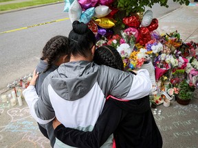 Mourners gather at a memorial to the 10 fatalities at the May 14, 2022 shooting at a Tops supermarket in Buffalo, N.Y. Authorities said the gunman was motivated by a white-nationalist racist ideology known as “replacement” theory.