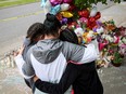 People look at a memorial in the wake of the May 14, 2022 shooting at a Tops supermarket in Buffalo, N.Y., that left 10 dead.