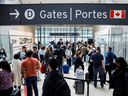 Travelers crowd the security area at Toronto Pearson International Airport on May 20, 2022. REUTERS/Cole Burston