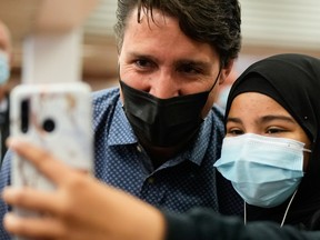 Prime Minister Justin Trudeau takes a selfie with a supporter, after the Liberals won a minority government, at the Jarry Metro station in Montreal,September 21, 2021.