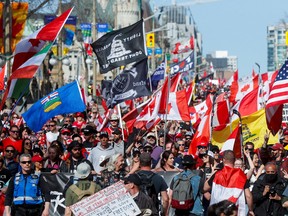 Demonstrators march holding flags during a Motorcycle-borne "Rolling Thunder Ottawa" protest in Ottawa, Ontario, Canada April 30, 2022. REUTERS/Lars Hagberg