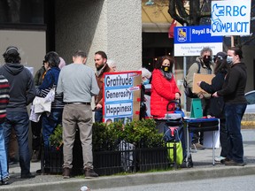Environmental activists outside an RBC branch in Vancouver, B.C., call on the bank to defund the Coastal GasLink project, April 7, 2022.