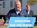 Der progressive konservative Führer von Ontario, Doug Ford, beantwortet Fragen von lokalen Medien, während George Pirie, der PC-Kandidat für Timmins, am 8. Mai 2022 zuschaut.