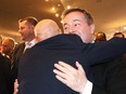 Jason Kenney hugs an unidentified supporter after announcing he was stepping down as the leader of the Alberta UCP, at Spruce Meadows in Calgary on May 18, 2022.
