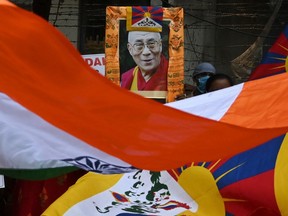 Aktivisten halten ein Porträt des 11. Panchen Lama, Gedhun Choekyi Nyima, und schwenken die Flaggen von Tibet und Indien während eines Protestes gegen die chinesische Invasion in Tibet am 23. April 2022 in Kalkutta.