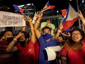 Supporters of presidential candidate Ferdinand Marcos Jr. celebrate as partial results of the 2022 national elections show him with a wide lead over rivals, outside the candidate's headquarters in Mandaluyong City, Philippines, May 9, 2022.