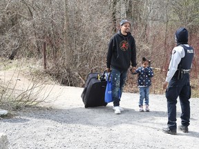 Asylum seekers cross into Canada from the U.S. border near a checkpoint on Roxham Road near Hemmingford, Quebec, Canada April 24, 2022.