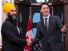 NDP Leader Jagmeet Singh and Prime Minister Justin Trudeau pose for photographers on March 24, 2022, shortly after sealing a deal in which the NDP would support the minority Liberals for the remainder of the term.